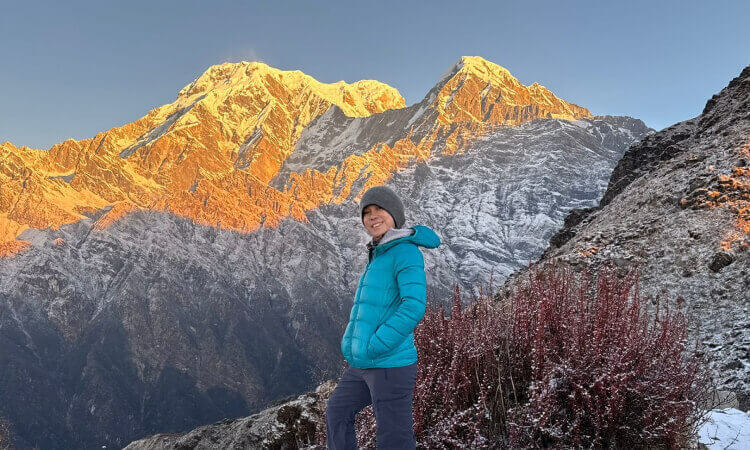 Solo female trekker on the Mardi Himal trekking route in Nepal with Annapurna South and Hiunchuli mountain views.