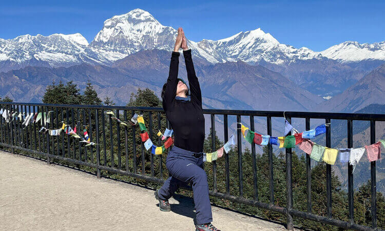 Solo Female trekker showing her yoga posture at Poon Hill